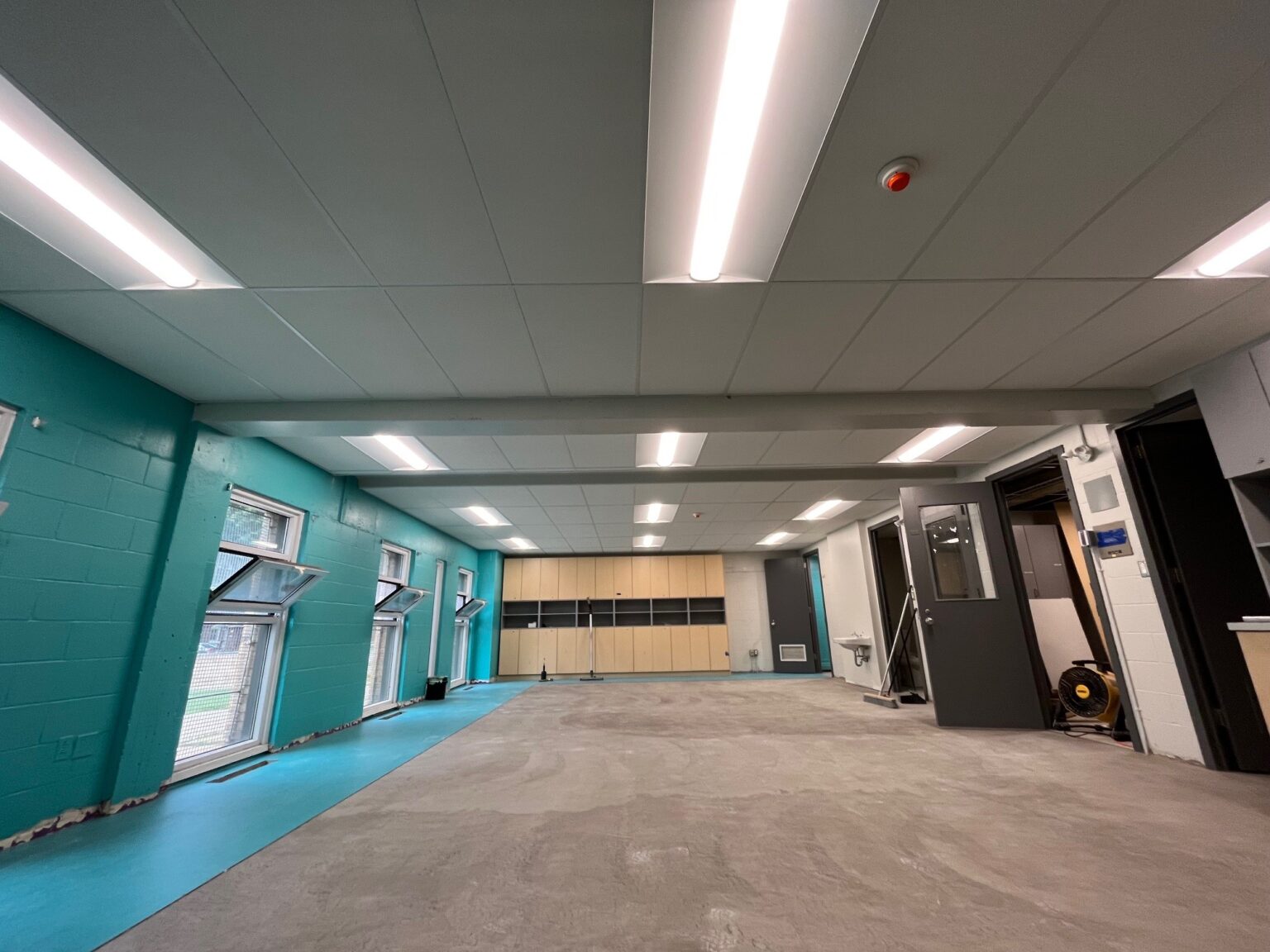 Salle vide avec murs turquoise.