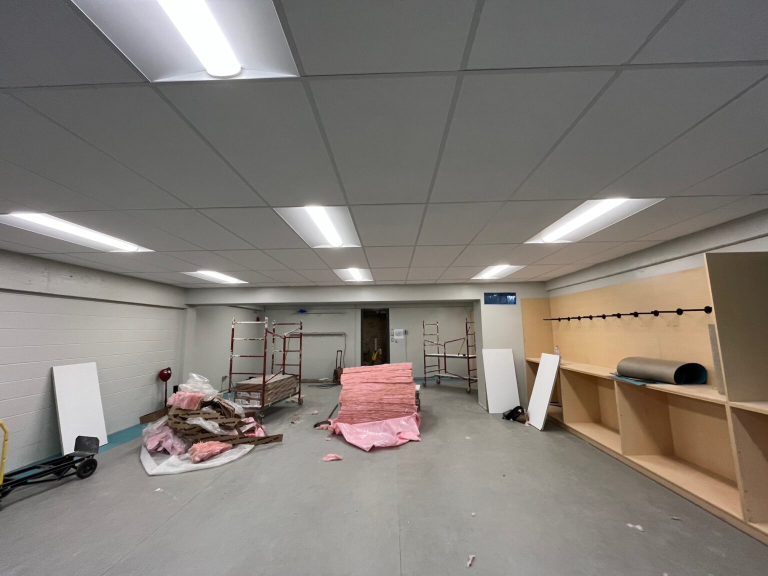 Salle en rénovation avec matériaux éparpillés.